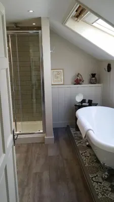 a bathroom with a large tub and a shower at Headland House Luxury B&B in St Ives