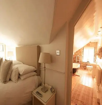 a bedroom with a bed and a lamp on a table at Headland House Luxury B&B in St Ives