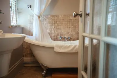 a bathroom with a bath tub and a sink at Headland House Luxury B&B in St Ives
