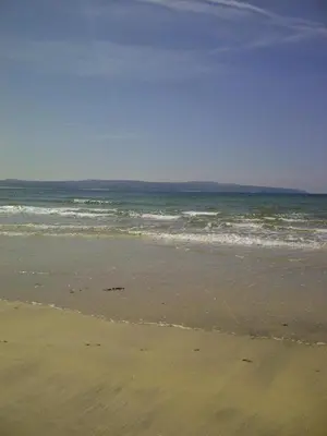 a sandy beach with the ocean in the background at Headland House Luxury B&B in St Ives