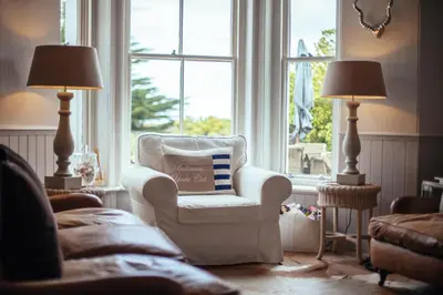 a living room with a chair and a window at Headland House Luxury B&B in St Ives