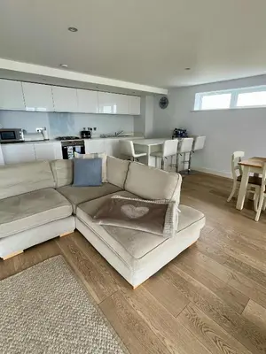 a living room with a couch and a kitchen at 6 Ocean Gate apartment in Newquay