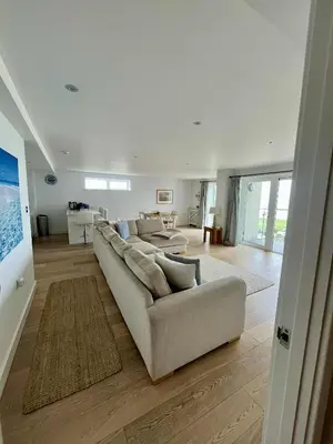a white living room with a couch and a table at 6 Ocean Gate apartment in Newquay