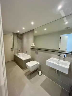 a bathroom with a toilet and a sink and a mirror at 6 Ocean Gate apartment in Newquay