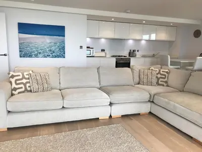 a living room with a couch and a kitchen at 6 Ocean Gate apartment in Newquay