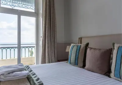 a bedroom with a bed and a large window at The Falmouth Hotel in Falmouth