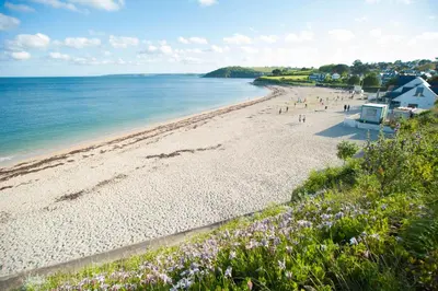a beach with a group of people and the ocean at The Falmouth Hotel in Falmouth