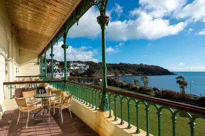 a balcony with a table and chairs and the ocean at The Falmouth Hotel in Falmouth