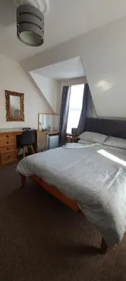 a bedroom with a large bed and a desk at Invernook in Newquay