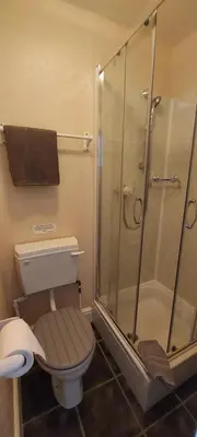a bathroom with a toilet and a glass shower at Invernook in Newquay