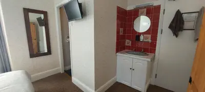 a small bathroom with a sink and a mirror at Invernook in Newquay