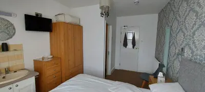 a small bedroom with a bed and a sink at Invernook in Newquay