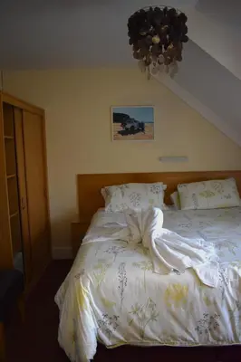 a bedroom with a bed with a white comforter at Harrington Guest House in Newquay