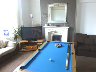 a living room with a pool table and a tv at Harrington Guest House in Newquay