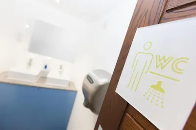 a sign on a door of a bathroom with a sink at Cohort Hostel in St Ives