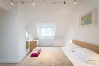 a bedroom with a bed with a red suitcase on the floor at Camana in St Ives