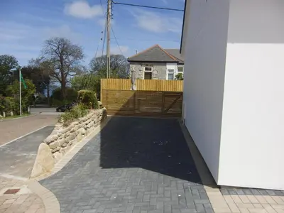 a driveway leading to a house with a wooden gate at Camana in St Ives