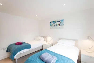 two beds in a room with white walls at Camana in St Ives