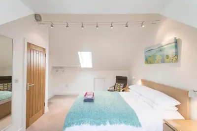 a bedroom with a large bed with a blue blanket at Camana in St Ives