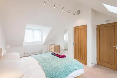 a bedroom with a bed with a blue blanket on it at Camana in St Ives