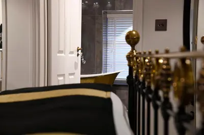 a bedroom with a bed with black and gold pillows at Padstow Townhouse in Padstow