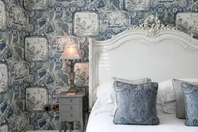 a bedroom with blue and white wallpaper and a bed at Padstow Townhouse in Padstow