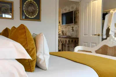 a bedroom with a bed with white sheets and pillows at Padstow Townhouse in Padstow