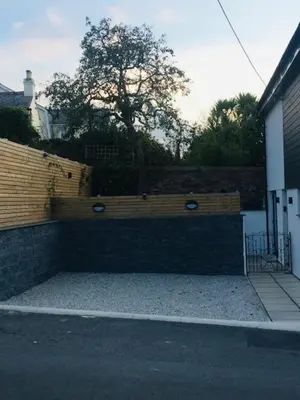 a brick wall with a bench in front of a building at Brookdale House in Wadebridge