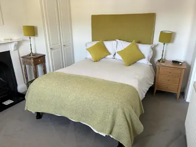 a bedroom with a white bed with yellow pillows at Brookdale House in Wadebridge