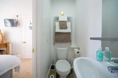 a bathroom with a toilet and a sink and a tub at Brookdale House in Wadebridge