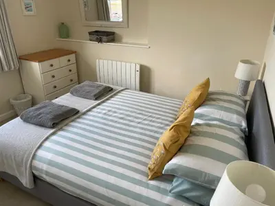 a bedroom with a bed with blue and white stripes at 2 Fernleigh Villas in Perranporth