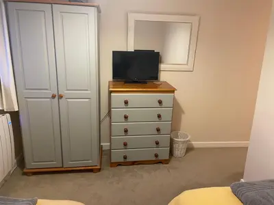 a bedroom with a dresser with a television on it at 2 Fernleigh Villas in Perranporth