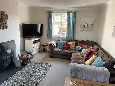 a living room with a couch and a tv at 2 Fernleigh Villas in Perranporth