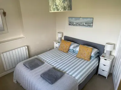 a small bedroom with a bed and a night stand at 2 Fernleigh Villas in Perranporth