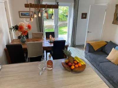 a living room with a table with a bowl of fruit at 2 Fernleigh Villas in Perranporth