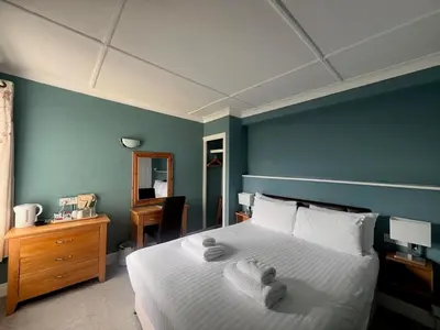 a bedroom with a bed and a blue wall at Pentire Newquay Cornwall Hotel in Newquay