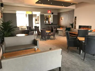 a restaurant with couches and tables and chairs at Pentire Newquay Cornwall Hotel in Newquay