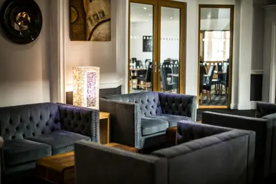 a waiting room with couches and tables and chairs at Pentire Newquay Cornwall Hotel in Newquay