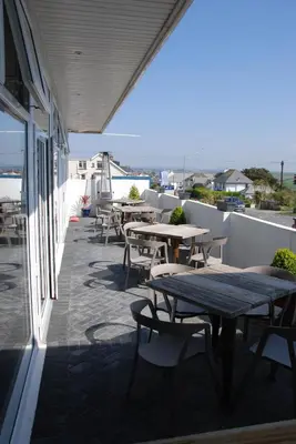 a row of tables and chairs on a patio at Pentire Newquay Cornwall Hotel in Newquay