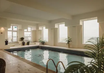 a swimming pool in a building with windows at Atlantic Hotel Newquay in Newquay