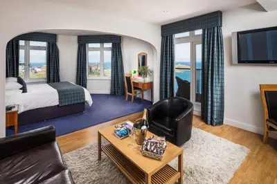 a hotel room with a bed and a living room at Atlantic Hotel Newquay in Newquay