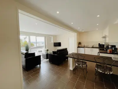 a kitchen and living room with a table and chairs at Atlantic Hotel Newquay in Newquay