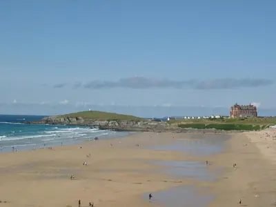 a group of people on a beach near the ocean at The Blue Palms - Fistral Beach in Newquay