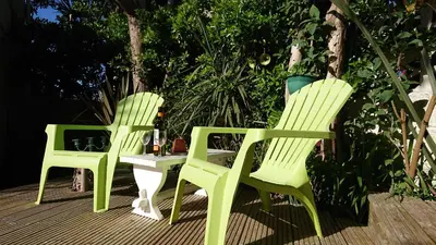 two green chairs and a table on a deck at The Blue Palms - Fistral Beach in Newquay