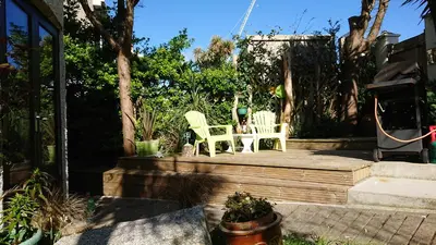two green chairs sitting on a wooden deck at The Blue Palms - Fistral Beach in Newquay