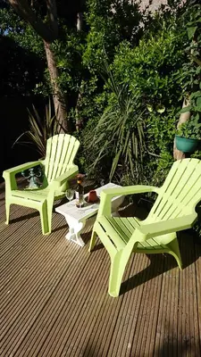 two green chairs and a table on a deck at The Blue Palms - Fistral Beach in Newquay