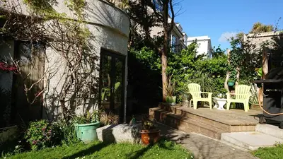 a backyard with two chairs and a wooden deck at The Blue Palms - Fistral Beach in Newquay