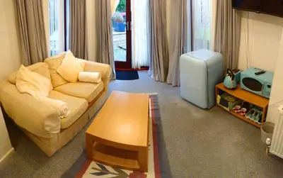 a living room with a couch and a table at The Blue Palms - Fistral Beach in Newquay