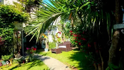 a garden with a bench and some plants and flowers at The Blue Palms - Fistral Beach in Newquay