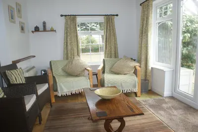 a living room with two chairs and a table at Nanis in Crantock